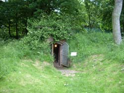 view of the ice house entrance set into a grass covered mound